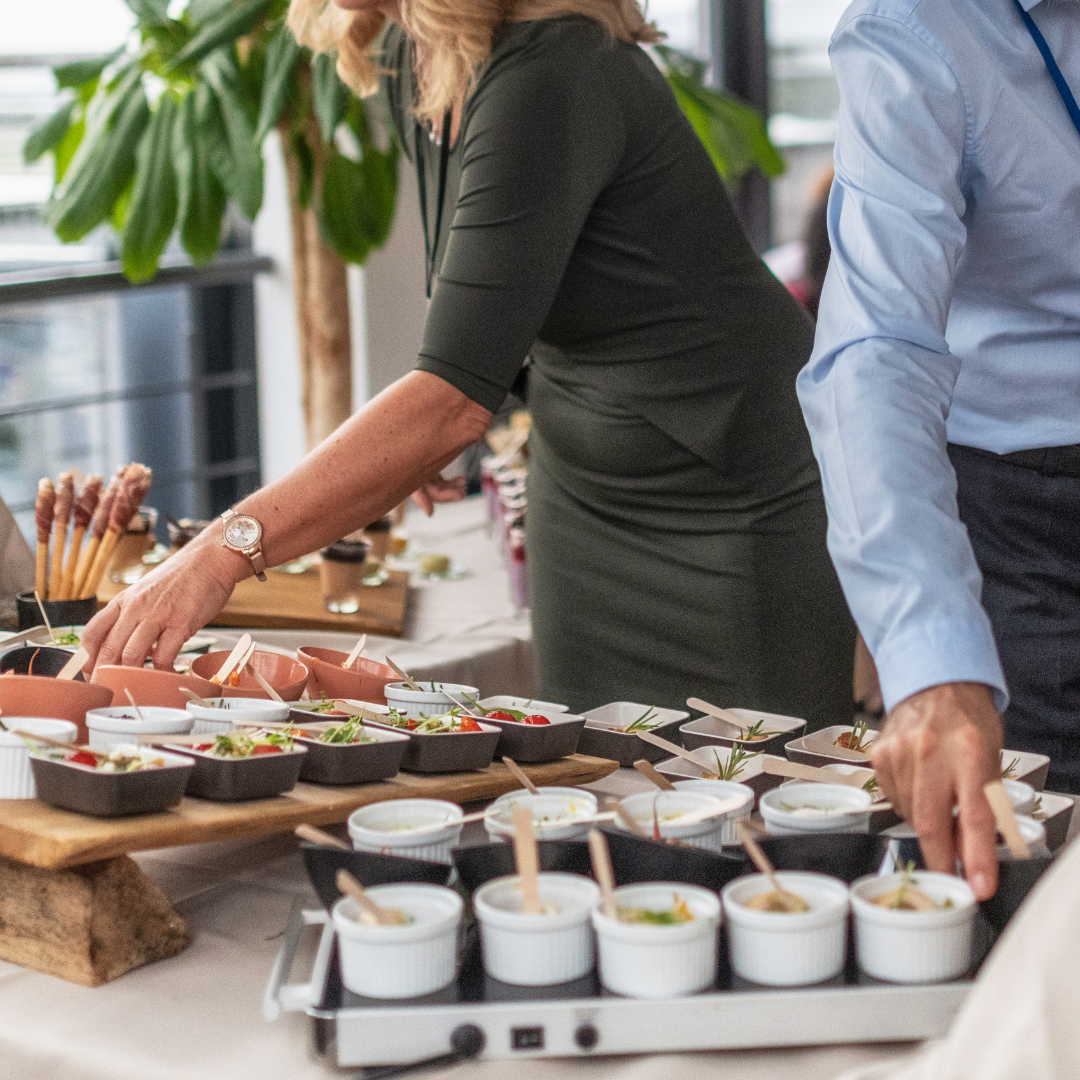 To personer som forsyner seg med mat ved en lunsjbuffet
