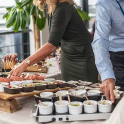 To personer som forsyner seg med mat ved en lunsjbuffet