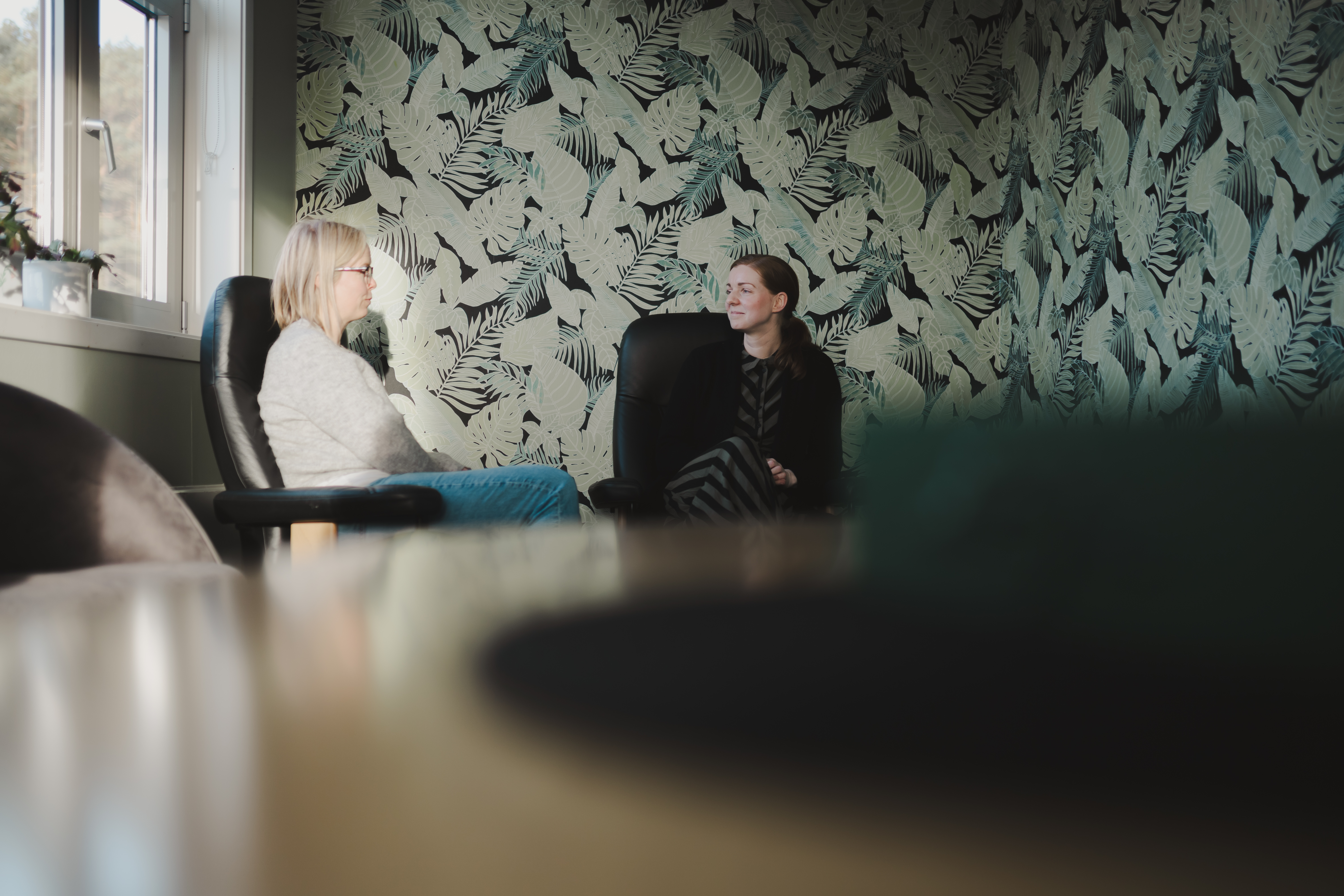to damer som sitter og snakker sammen