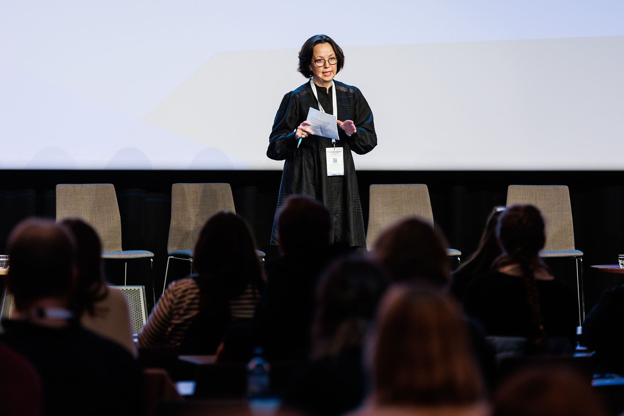 Marit Morken står på scenen og snakker