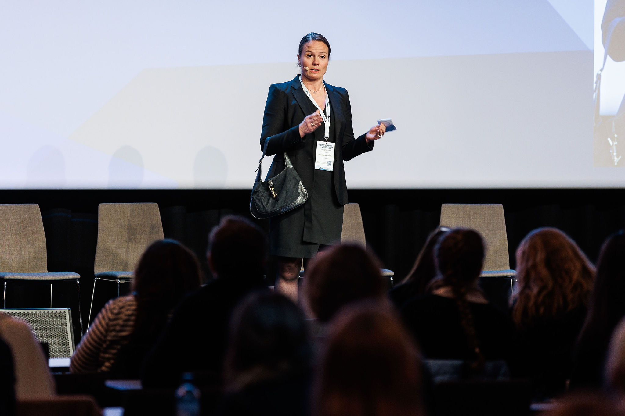 Gigja Gudbrandsdottir står på scenen og snakker