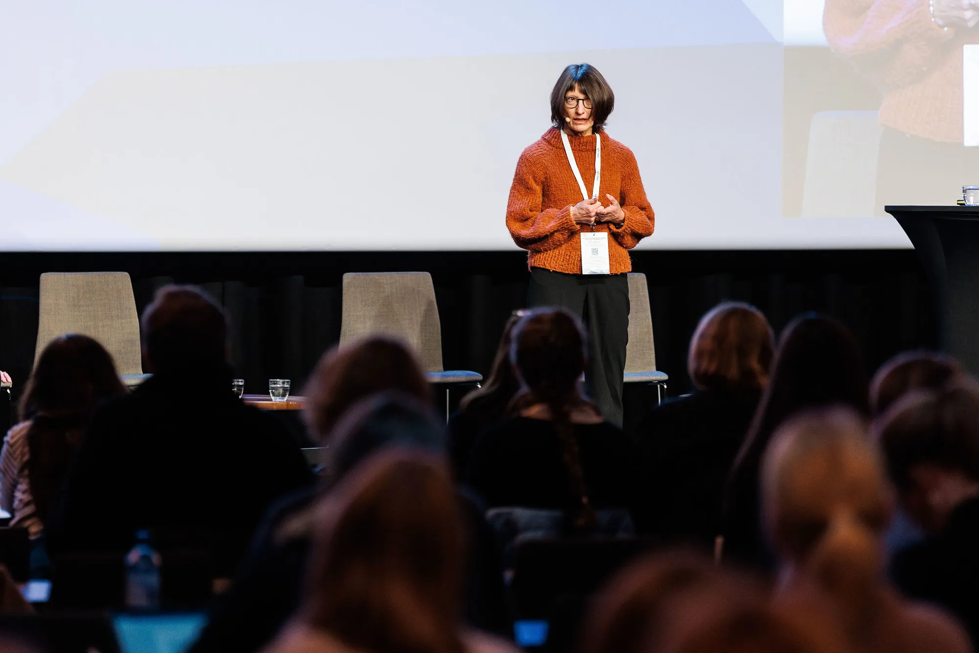 Nina Evjen står på scenen og snakker